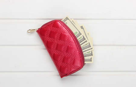 Red wallet with hundred dollar bills on white wooden background. Top viewの写真素材