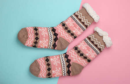 Warm cozy socks on pink blue background. Top view
