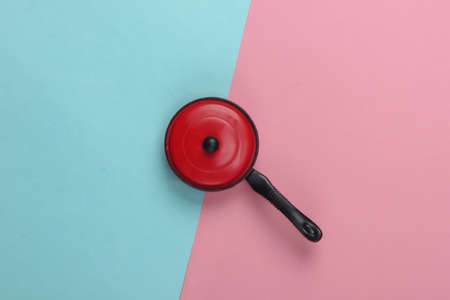 Toy plastic pan on pink blue pastel background. Kid's Kitchen. Top view, minimalismの写真素材