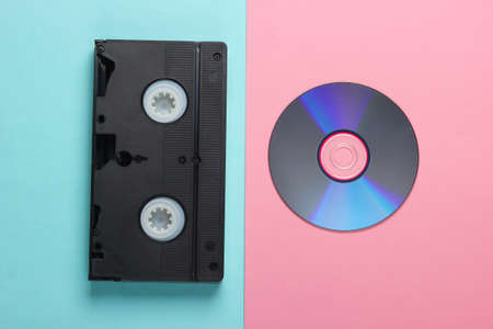 Flat lay composition of cd disc, audio cassette on pink blue background. Retro storage media. Top viewの写真素材