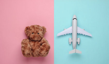 flat lay composition of a teddy bear, plane on a blue-pink pastel background. Tourism concept. Top viewの写真素材