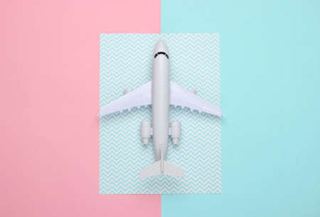 Toy model of plane on a blue-pink pastel background. The concept of tourism, air travel, minimalism. Top viewの写真素材