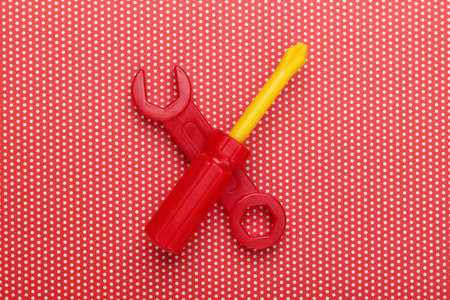 Children's toy tool. Wrench, screwdriver on a  polka dot tablecloth. Top viewの写真素材