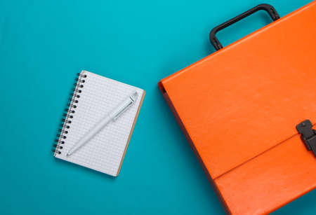 Orange paper case, notebook on a blue background. Top viewの写真素材