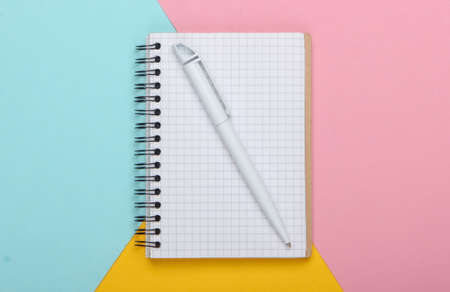 Notebook on pastel colored background. Top view