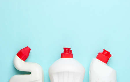 Bottle of detergent on blue pastel background. House cleaning concept. Minimalism. Top view. Copy...