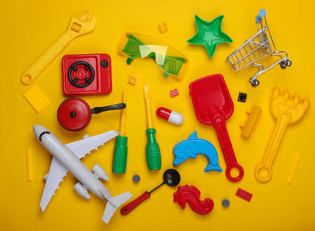 A lot of various children's toys on a yellow background. Childhood concept. Top viewの写真素材
