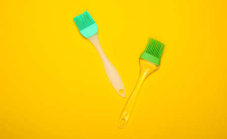 Kitchen spatula and brush on yellow background. Top viewの写真素材