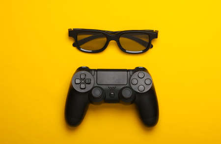 Gamepad, 3d glasses on yellow background. Gaming, leisure and entertainment concept. Top viewの写真素材