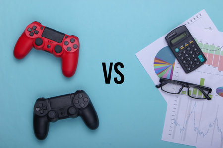 Entertainment or work. Gamepads, charts and diagrams, glasses and calculator on a blue background....