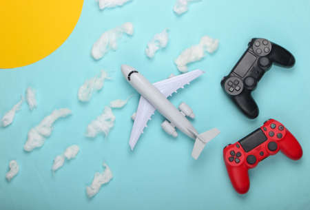 Air game. Gamepads, toy plane on a background of the sunny sky with clouds. Top view