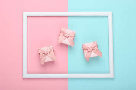 Gift boxes on pink blue pastel background with white frame. Studio shot. Creative flat lay. Top...