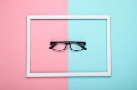 Eyeglasses in white frame on pink blue pastel background. Top viewの写真素材