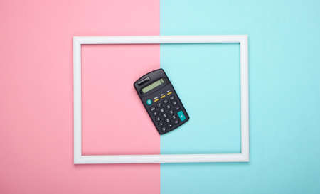 Calculator in white frame on pink blue pastel background. Top view