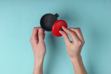 Female hands hold a mini toy pan on blue pastel background.の写真素材