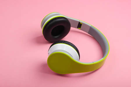 Stylish wireless stereo headphones on pink pastel background. Music lover. Gadgets.