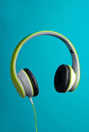 Modern wired stereo headphones on blue background.の写真素材