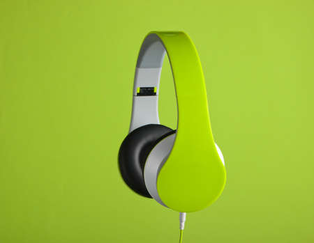 Modern wired stereo headphones on a green background.の写真素材