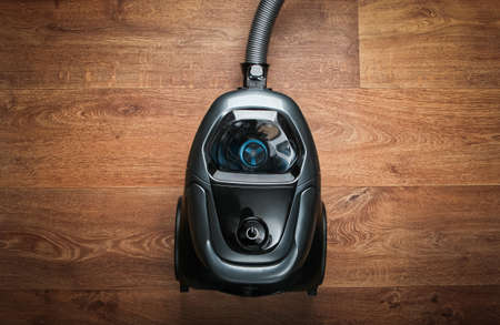 Vacuum cleaner on wooden floor. Top view. Cleaning concept.の写真素材