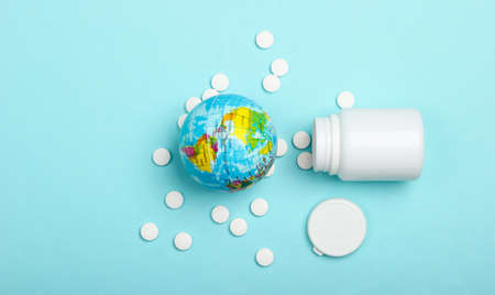 Global epidemic, pandemic concept. Globe with a bottle of pills on a blue background.の写真素材