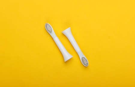 Interchangeable head nozzles of electric toothbrush on a yellow background