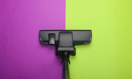 Vacuum cleaner brush on green purple background. Top view. Cleaning concept.