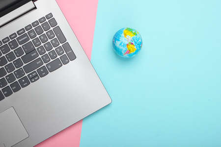 Global network, internet. Laptop and globe on pink blue pastel background. Top view. Minimalismの写真素材