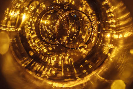 Gold wedding rings with champagne bubbles with yellow backlight. Wedding conceptの写真素材
