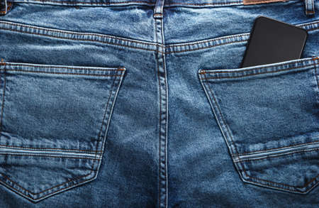 Smartphone in the back pocket of blue jeansの写真素材