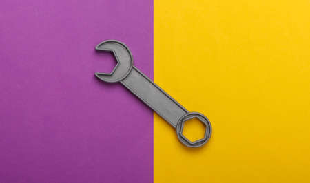 Toy wrench on a purple yellow background. Top viewの写真素材