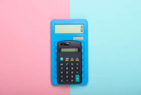 Two calculators on blue pink pastel background. Top view.の写真素材