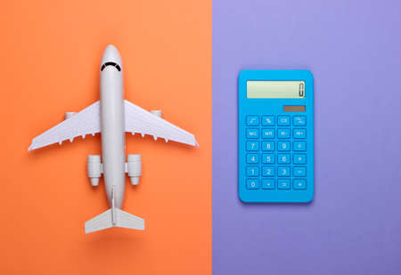 Calculation of the cost of travel, air travel or air delivery. Calculator with airplane figure on purple-orange background. Top viewの写真素材
