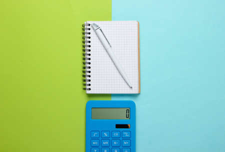 Calculator with notebook on blue green background. Education process. Top view. Flat layの写真素材