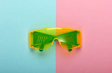 Safety glasses on a blue-pink pastel background. Top viewの写真素材