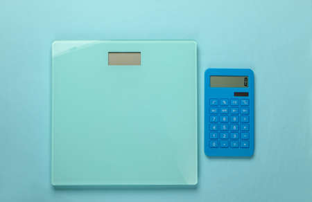 Diet, weight loss still life. Calorie Counting. Calculator and scales on blue background....