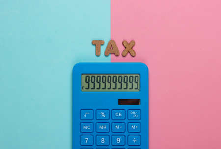 Calculator with the word tax on pink blue pastel background. Top viewの写真素材