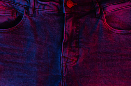 Jeans in a neon blue-red gradient light.の写真素材