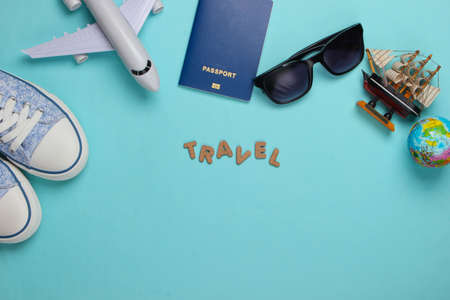 Travel concept. Traveler accessories on a blue background with the word travel. Cruise, air flight, vacation. Top view. Flat lay. Copy spaceの写真素材