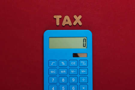 Calculator with the word tax on a red background. Top viewの写真素材