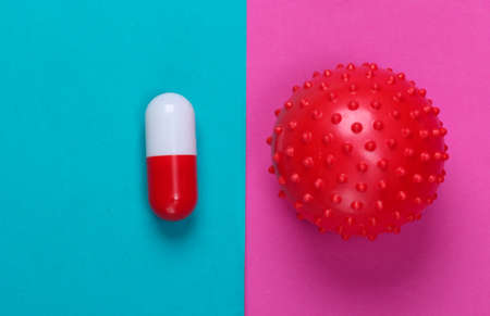 Coronavirus treatment. Virus strain and pill on blue pink background. Medical concept. Pandemic