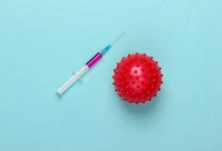 Coronavirus vaccine. Virus strain and syringe on a blue pastel background. Vaccination. Medical concept. Pandemicの写真素材