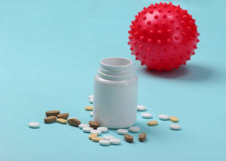 Coronavirus treatment. Virus strain and pill bottle on blue background. Medical concept. Pandemicの写真素材