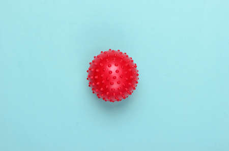 Red massage ball on a blue background. Minimalism. Health care, fitness concept.の写真素材