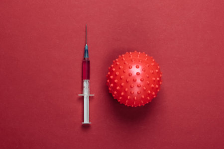 Coronavirus vaccine. Virus strain and syringe on red background. Vaccination. Medical concept. Pandemicの写真素材
