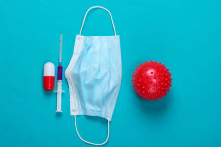 World pandemic. Syringe, mask, pill, virus strain on blue background. Vaccination. Coronavirus; n-cov2019. Top view. Flat layの写真素材