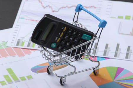 Calculator in a shopping cart on graphs and charts.の写真素材