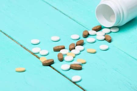 Bottle of pills on a blue wooden background.の写真素材