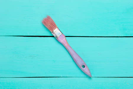 Paint brush on a blue painted wooden backgroundの写真素材