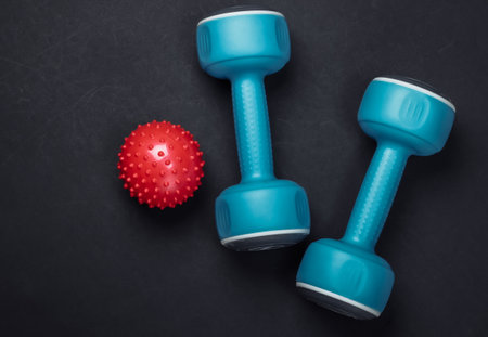 Dumbbell with massage ball on black background. Fitness, healthy lifestyle concept. Studio shot.の写真素材