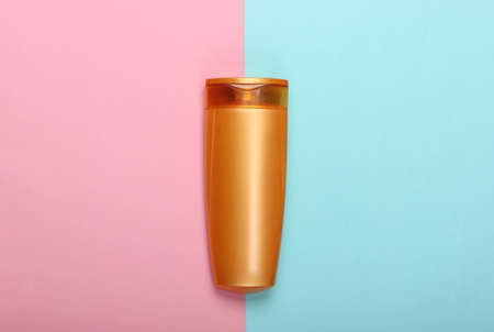 Shampoo bottle on pink blue pastel background. Hair care. Hygiene and cosmetics. Beauty flat lay. Top viewの写真素材